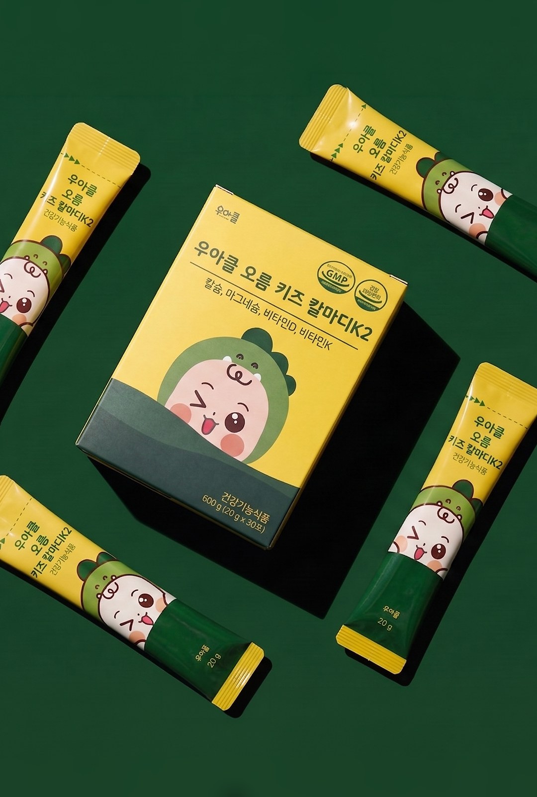 Wooahcl Oreum Kids CalMagD K2 box and four stick packs on a deep green background