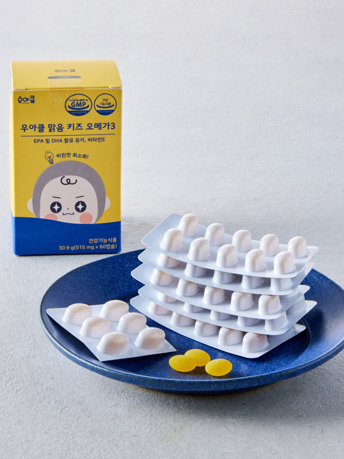 접시에 놓인 맑음 키즈 오메가3 낱개 포장과 캡슐
